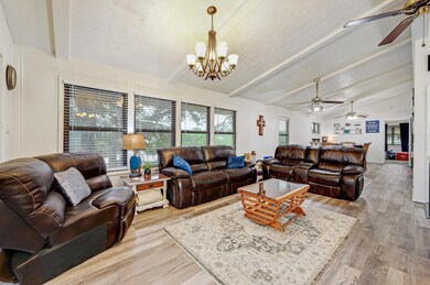 Living room featuring ceiling fan, a chandelier, 