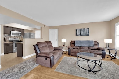 Living area featuring baseboards and light wood fi
