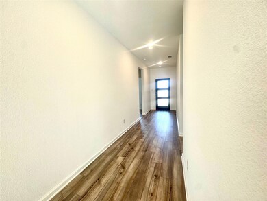 Hallway featuring baseboards, dark wood-style floo