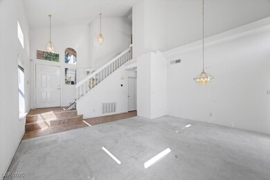 Carpeted entrance foyer featuring vaulted ceiling, stairway, and a chandelier