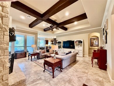 Living area featuring coffered ceiling, ceiling fa