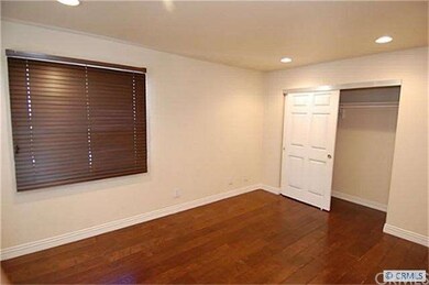 1st bedroom with canned lighting and wood floors