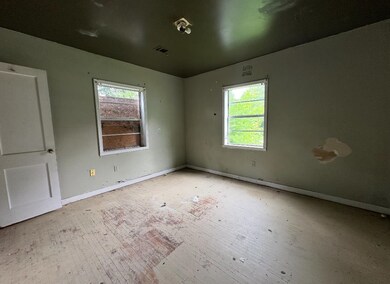 Spare room featuring plenty of natural light, baseboards, and hardwood / wood-style floors