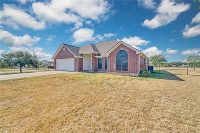 Ranch-style home with brick siding, driveway, an attached garage, and roof with shingles