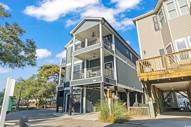 View of front of home featuring board and batten siding, a carport, an attached garage, and driveway