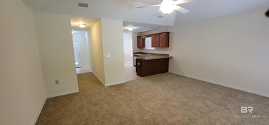 Kitchen with light carpet, ceiling fan, and a peninsula