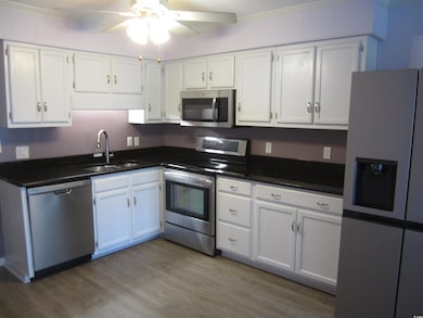Kitchen with white cabinetry, sink, hardwood / woo