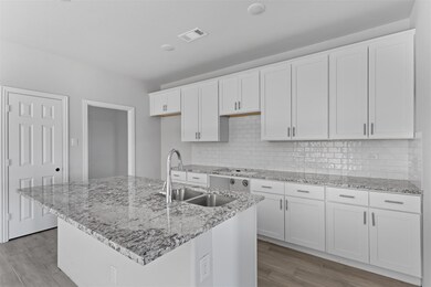 Kitchen featuring white cabinetry, light hardwood 