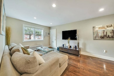 Living area featuring a wall unit AC, dark wood fi