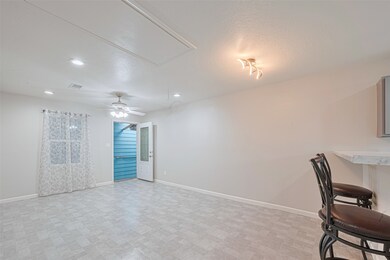 Open living space with tile flooring, ceiling fan,