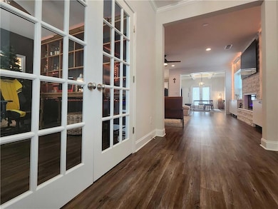 Hallway with wood finished floors, crown molding, french doors, and recessed lighting