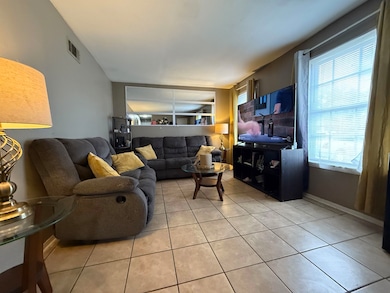 Living room with light tile patterned floors and baseboards