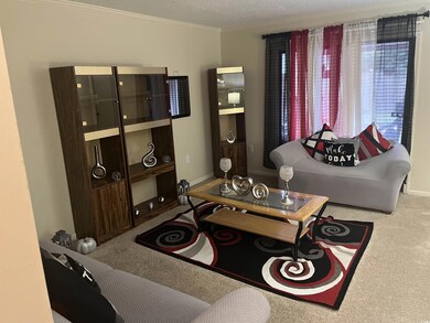 Living room featuring carpet flooring, a textured 