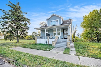 Bungalow-style home with a porch, a front lawn, and a shingled roof