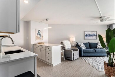 Living area with light wood-style flooring, ceiling fan, and recessed lighting