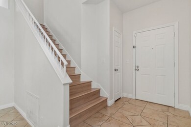 Foyer with light tile patterned flooring and stairway