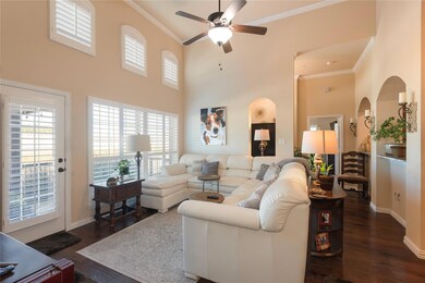 Living room with a high ceiling, ceiling fan, crow