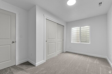 Unfurnished bedroom featuring carpet floors, baseboards, visible vents, and a closet