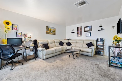 Carpeted living room with visible vents