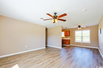 Unfurnished living room featuring light wood-type flooring and a ceiling fan