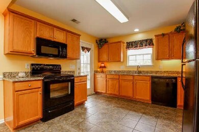 Open Kitchen with new tile floors and granite counters. All of the Kitchen applainces remain!