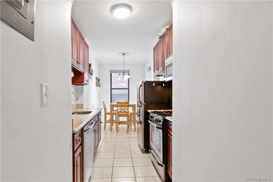 Kitchen featuring light tile patterned floors, sink, decorative light fixtures, appliances with stainless steel finishes, and a notable chandelier