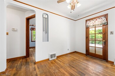Dining room with dark wood-type flooring, ornamental molding, and ceiling fan