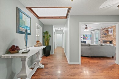 Corridor with hardwood / wood-style floors and a t