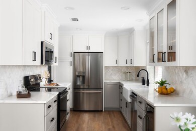 Kitchen featuring visible vents, a sink, wine coo