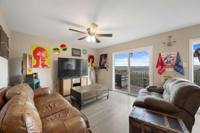 Living room featuring a ceiling fan and wood fini