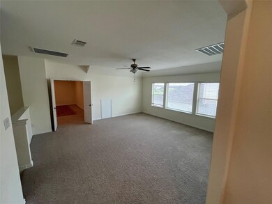 Carpeted empty room with ceiling fan and baseboar