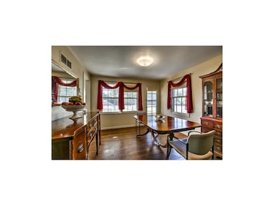 Formal dining room with lots of windows and wood f