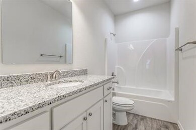 Bathroom featuring vanity, washtub / shower combination, and light wood-type flooring