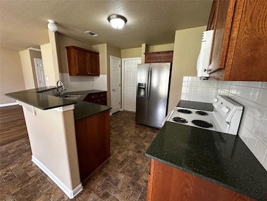 Kitchen with a peninsula, stainless steel fridge 