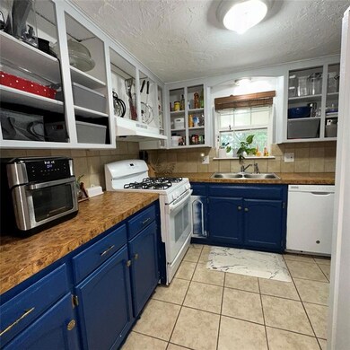 Kitchen with sink, blue cabinetry, white appliance