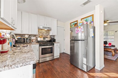 Kitchen featuring dark wood-type flooring, white c