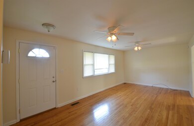 Great Room With Hardwood Flooring And Ceiling Fan