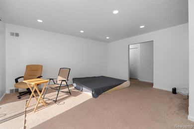 Bedroom featuring light colored carpet, recessed lighting, and a closet