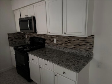 Kitchen featuring white cabinetry, stainless steel