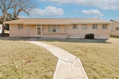 Back of property featuring a lawn and brick siding