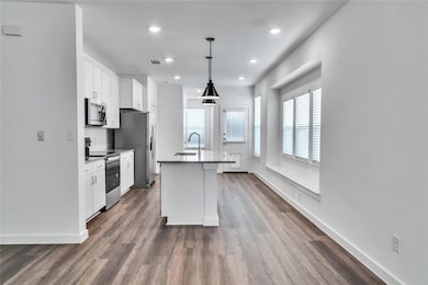 Kitchen with white cabinets, visible vents, stainl