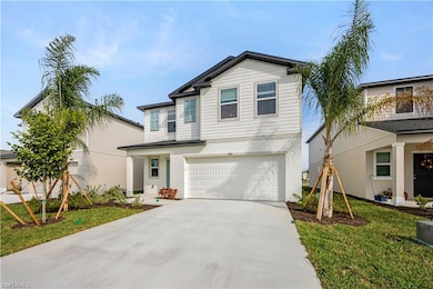 View of front of home with concrete driveway, a front yard, a garage, and stucco siding