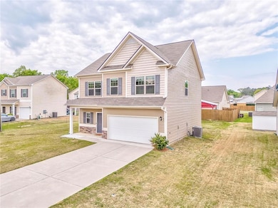 Craftsman-style home with a front yard, an attache