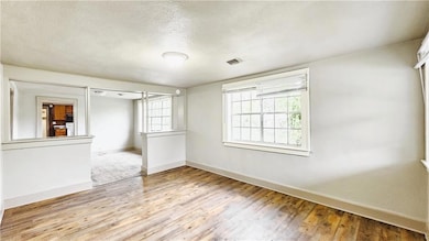 Empty room featuring visible vents, baseboards, an