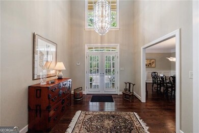 Entrance foyer with a high ceiling, french doors, a chandelier, and dark wood finished floors