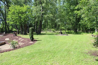 Backyard with fire pit, property extends past mowe
