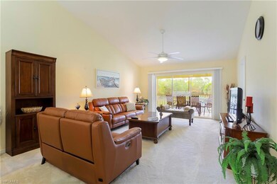 Carpeted living room featuring high vaulted ceiling and ceiling fan