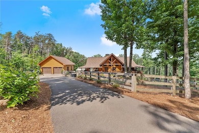 View of front of property with a detached garage, an outbuilding, and a chimney
