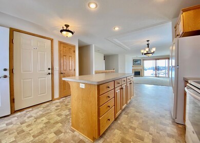 A kitchen view through the dining room to the living room and the deck beyond.