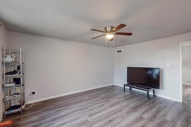 Living room featuring baseboards, ceiling fan, and